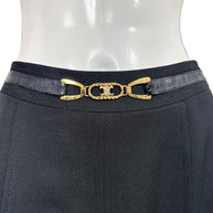 Close-up of vintage Céline skirt featuring a black leather belt, gold-tone interlocking Double-C emblem, and tailored black wool waistband.
