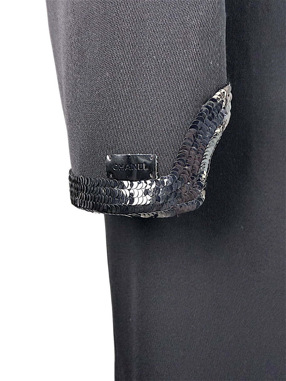 Close detail of Chanel logo plaque and tonal sequined trim on sleeve cuff