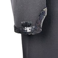 Close detail of Chanel logo plaque and tonal sequined trim on sleeve cuff