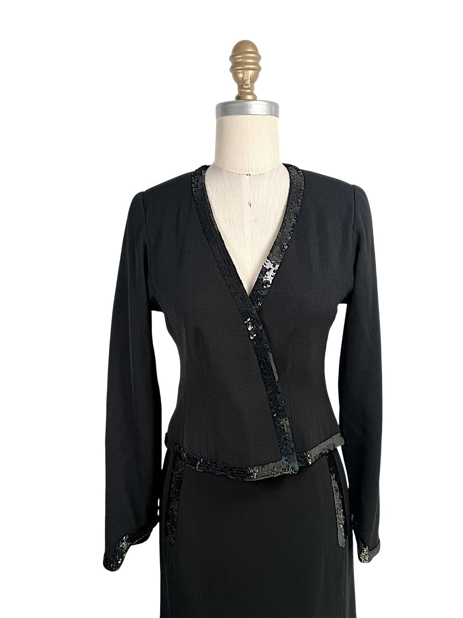 Close front view of vintage Chanel black skirt suit with black sequin trim and tailored wrap jacket silhouette
