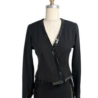 Close front view of vintage Chanel black skirt suit with black sequin trim and tailored wrap jacket silhouette