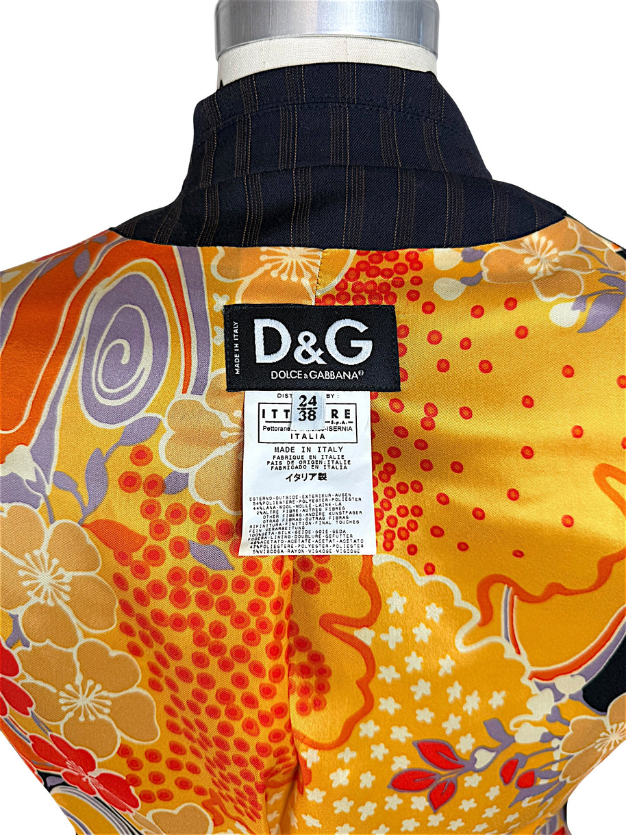 Close-up of original D&G Dolce & Gabbana Made in Italy designer label, Italian size 38 and fabric composition tag against colorful floral lining.
