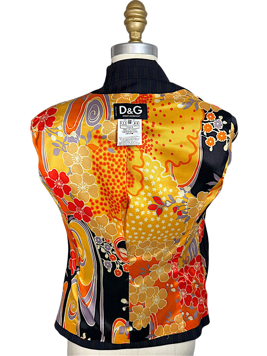 Interior of vintage D&G Dolce & Gabbana blazer displaying vibrant orange, yellow, red and lavender floral silk lining with original designer label.