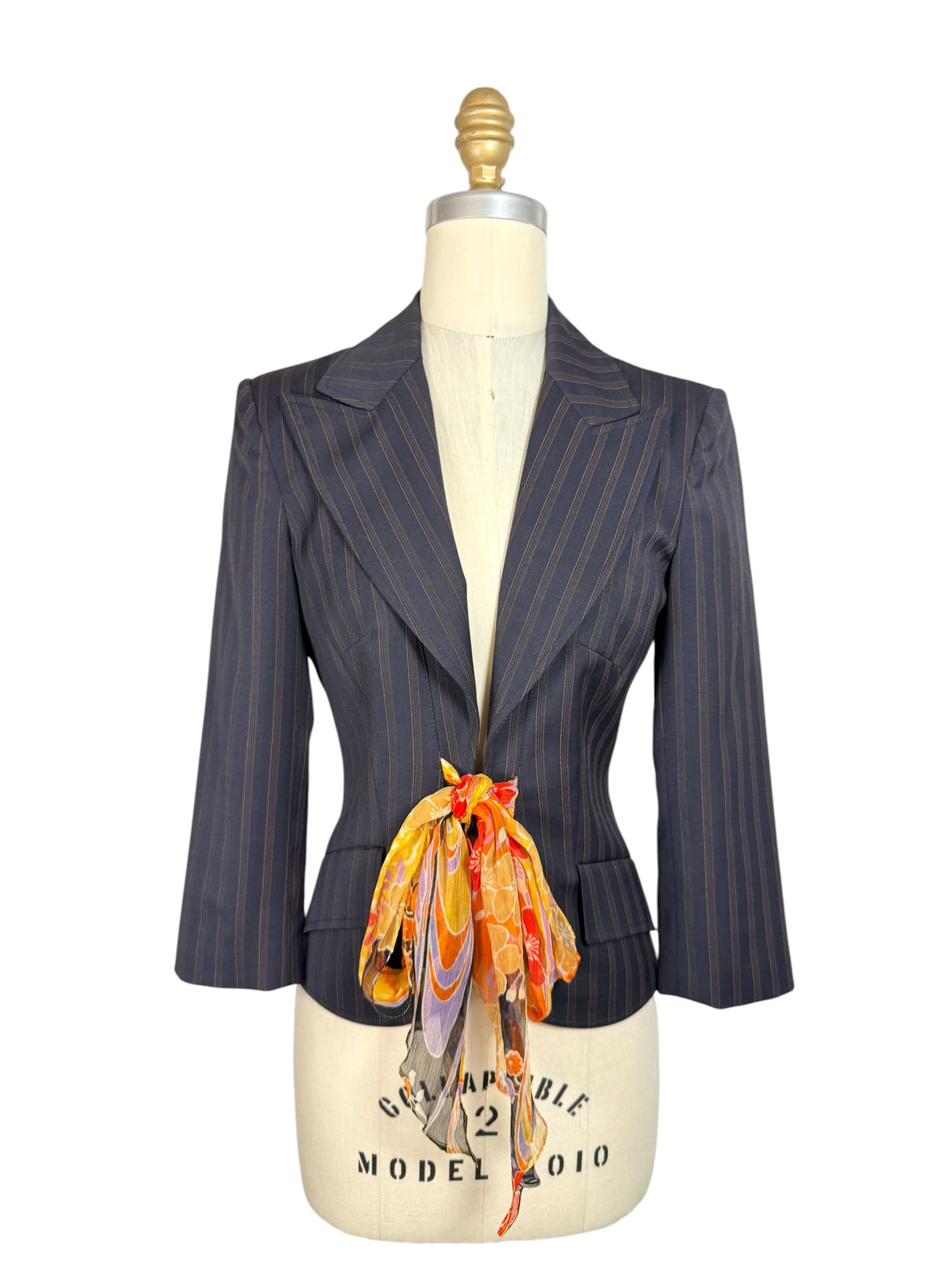Vintage D&G by Dolce & Gabbana navy pinstripe tailored blazer with structured shoulders, fitted waist and colorful floral silk scarf tie, front view.