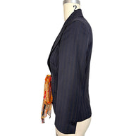 Opposite side view of vintage D&G Dolce & Gabbana navy pinstripe fitted blazer highlighting structured shoulder, tailored sleeve and colorful silk waist tie.
