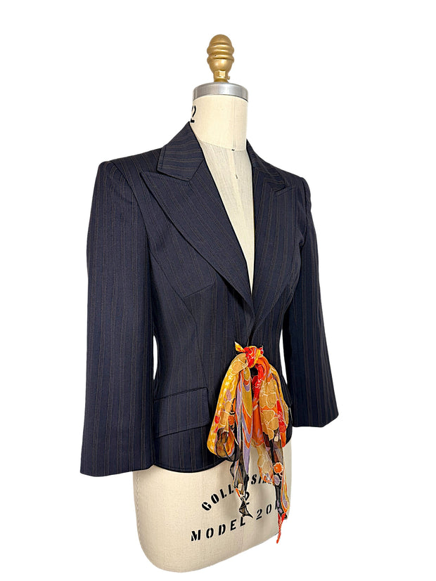 Three-quarter view of vintage D&G Dolce & Gabbana navy pinstripe blazer featuring notched lapels, sculpted waist and vibrant floral silk tie.