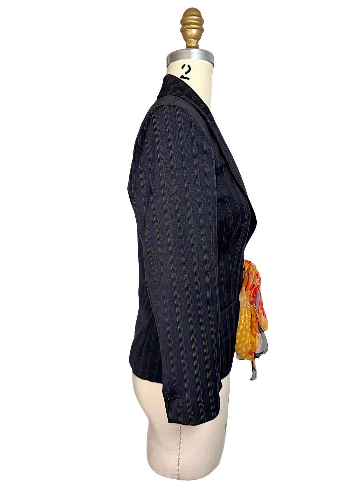 Side profile of vintage D&G Dolce & Gabbana navy pinstripe tailored blazer showing three-quarter-length sleeve, defined waist and floral scarf tie.