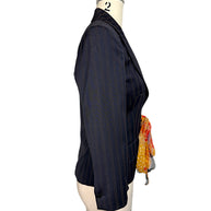 Side profile of vintage D&G Dolce & Gabbana navy pinstripe tailored blazer showing three-quarter-length sleeve, defined waist and floral scarf tie.