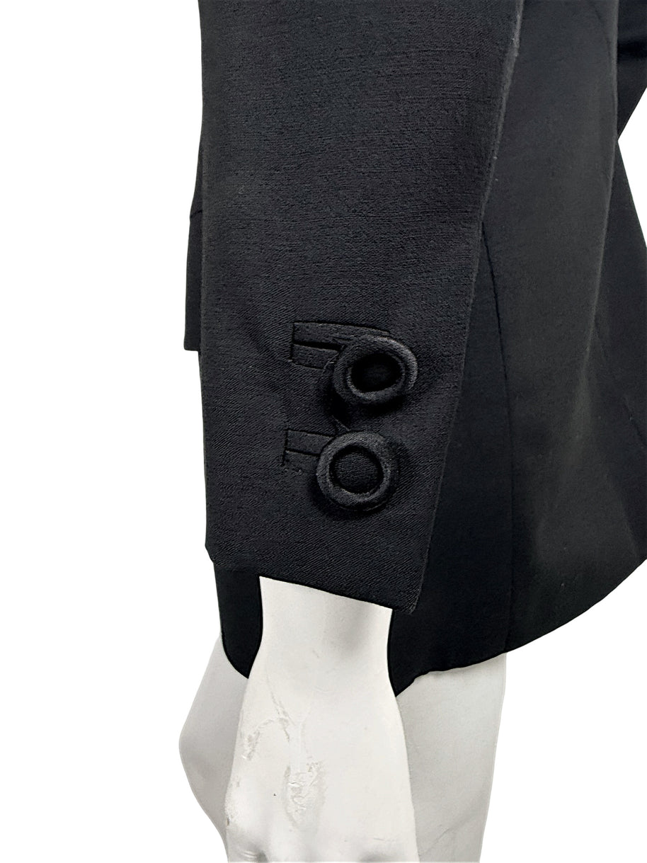 Close-up of two circular black fabric-covered cuff buttons and tailored sleeve vent on a vintage Gianni Versace Couture blazer.
