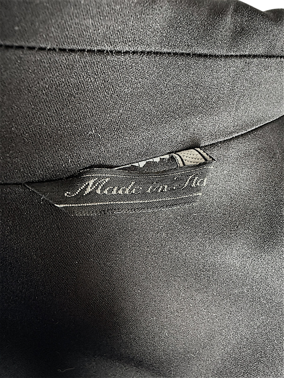 Close-up of the interior Made in Italy label and black lining inside a vintage Gianni Versace Couture tailored blazer.
