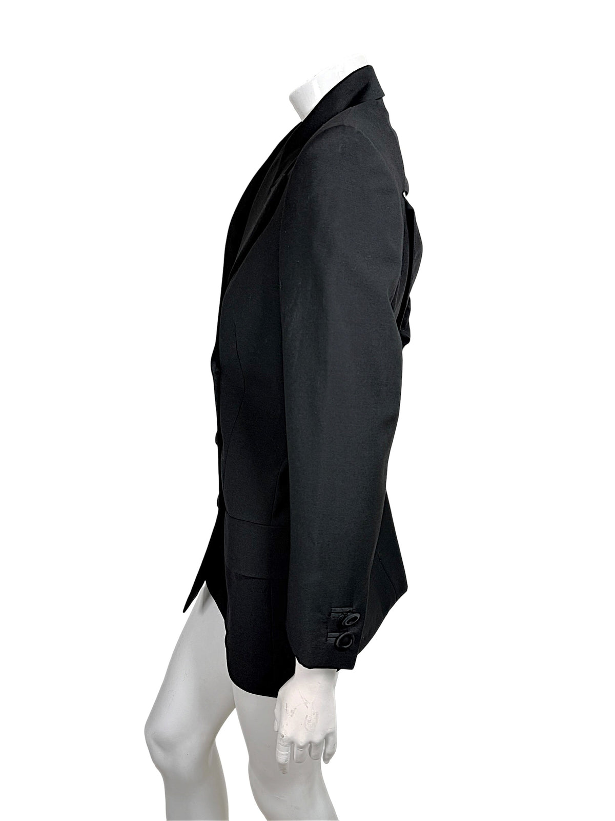 Side view of vintage Gianni Versace Couture black longline blazer showing tailored waist shaping, structured shoulder and decorative sleeve buttons.