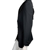 Side view of vintage Gianni Versace Couture black longline blazer showing tailored waist shaping, structured shoulder and decorative sleeve buttons.