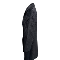 Side profile of vintage Guy Laroche Paris Collection black quilted longline jacket with structured silhouette.