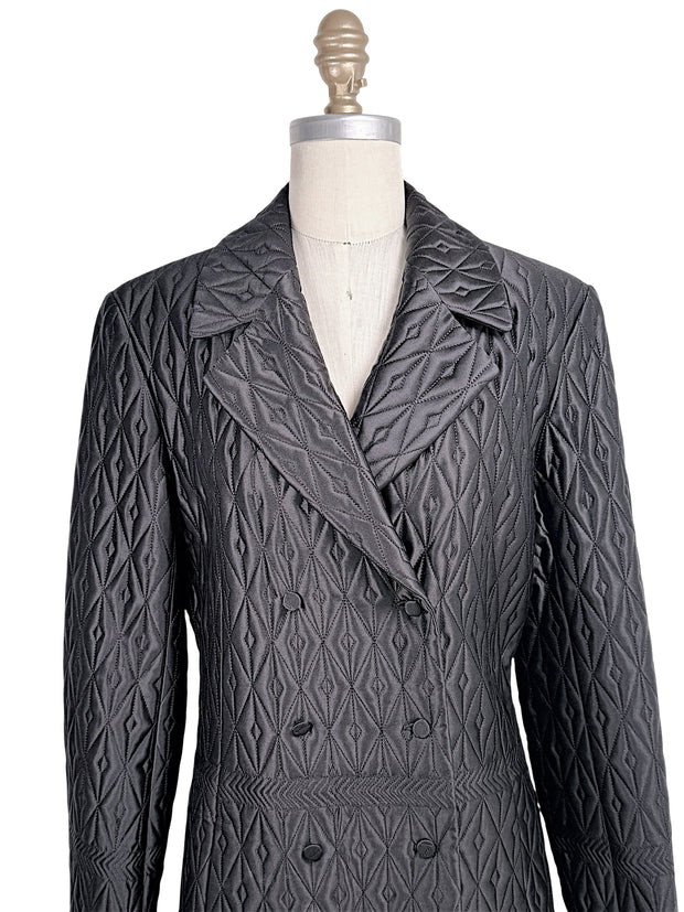 Close-up of vintage Guy Laroche Paris black quilted jacket showing double-breasted covered buttons, lapels, and geometric stitching.